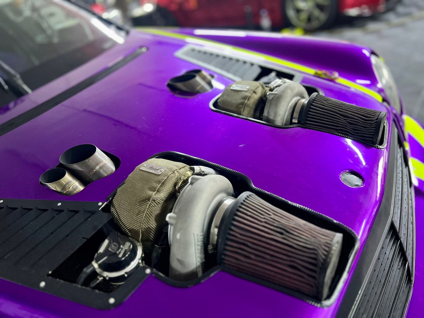 Detail of the bonnet with twin turbos and purple vinyl wrap