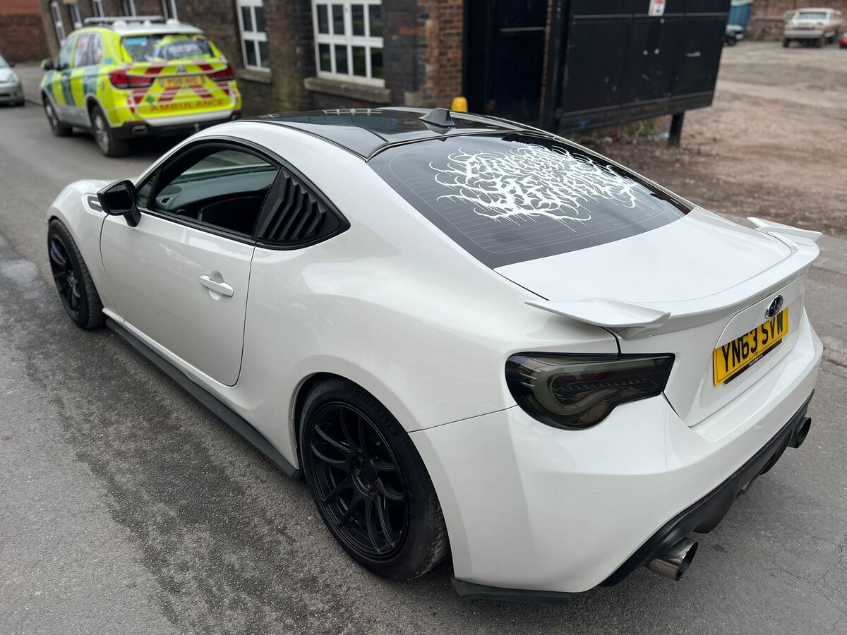 White Subaru BRZ with custom tattoo-style rear window vinyl graphics three-quarter outdoor view by Wizz's Wraps Stoke-on-Trent