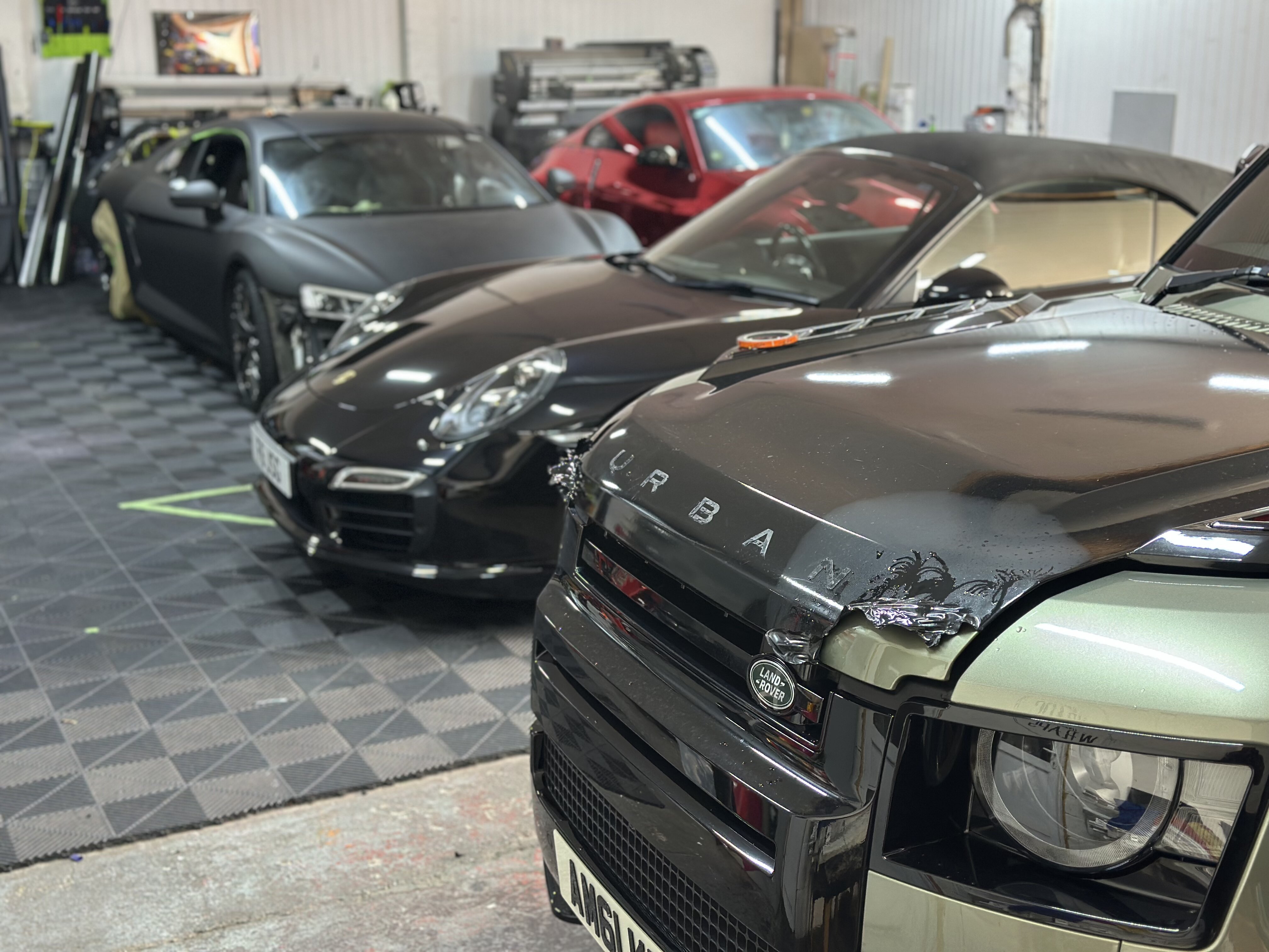 Inside the Wizz's Wraps workshop in Stoke-on-Trent with Porsche, Land Rover and other vehicles